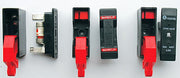 Red and black fuse holder lockout clips, several units shown
