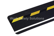 Safety grip strip close-up: yellow diagonal hazard stripes on dark grip, white reflective border