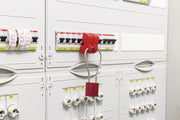 Red circuit breaker lockout device installed on breaker in electrical panel