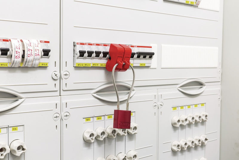 Red circuit breaker lockout device installed on breaker in electrical panel