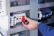 Red circuit breaker lockout device being installed by hand on breaker