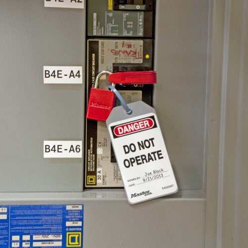 Red circuit breaker lock with danger tag on electrical panel