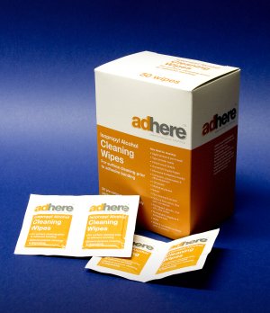 Adhere cleaning wipes box with individual wipe packets on a tabletop