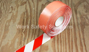 Floor hazard tape roll with diagonal red and white stripes, wound on orange core
